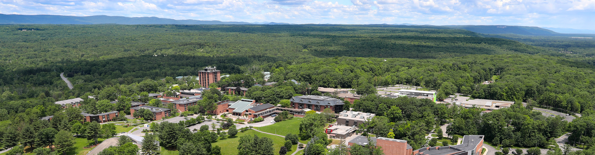 aerial view over a college campus surrounded by woods